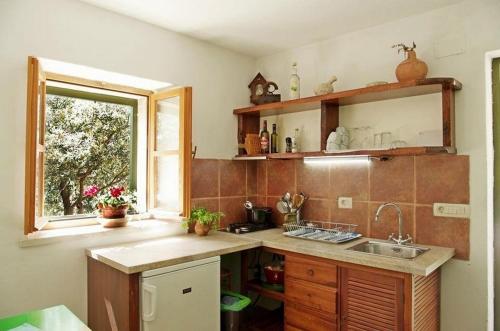 a kitchen with a sink and a window at Secluded fisherman's cottage Cove Vela Studena, Brac - 20904 in Selca