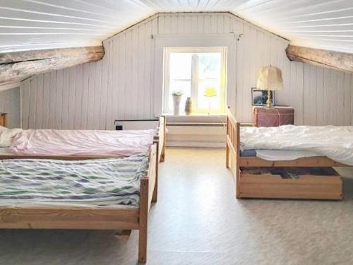 um quarto com três camas e uma janela em Holiday home BJURHOLM II em Bjurholm