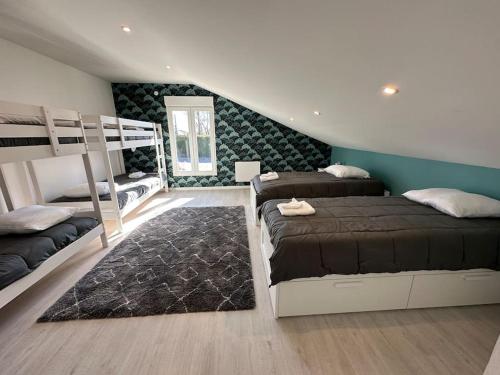 a bedroom with two bunk beds and a rug at Gite 5 chambres, piscine intérieure, proche du Der 