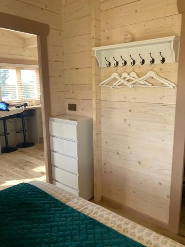 ein Schlafzimmer mit einem Bett und einer Holzwand in der Unterkunft Dolmen Lodge. in Donegal