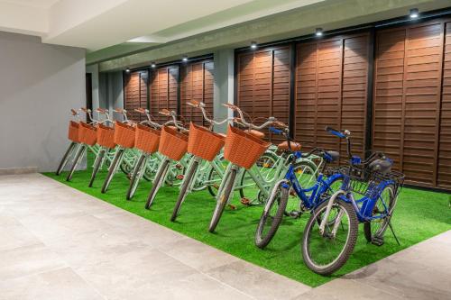 eine Reihe von Fahrrädern in einer Reihe mit Gras in der Unterkunft Kippal - Modern Oasis - ApartHotel in Cozumel