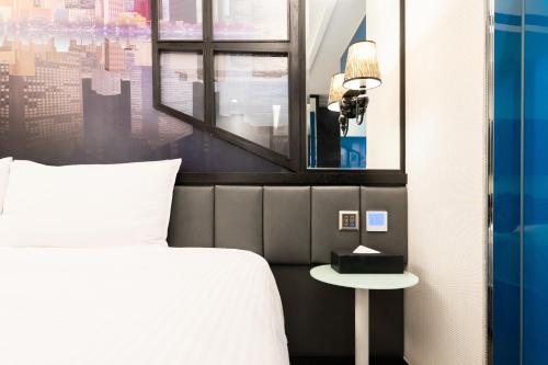 a bedroom with a bed and a mirror and a table at The Cloud Hotel in Kaohsiung