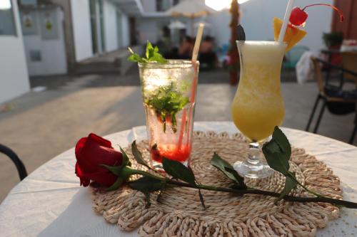two cocktails sitting on a table with roses on it at La Estancia Hotel Ica in Ica