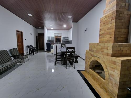 a living room with a fireplace and tables and chairs at Tranquil Ridge Hilltop Bungalow in Hatton