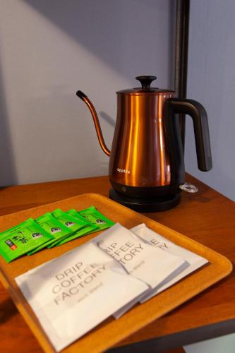 a tea pot and a cake on a table at Code Rooms Imaizumi in Fukuoka