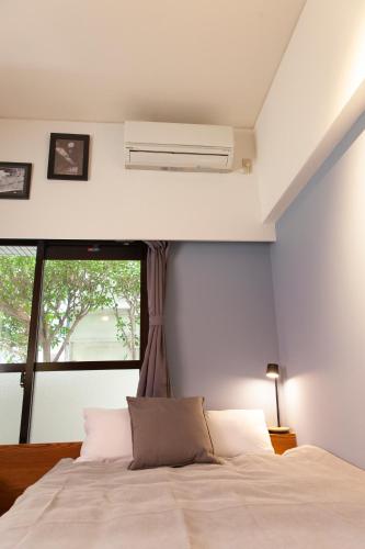 a bedroom with a white bed and a window at Code Rooms Imaizumi in Fukuoka
