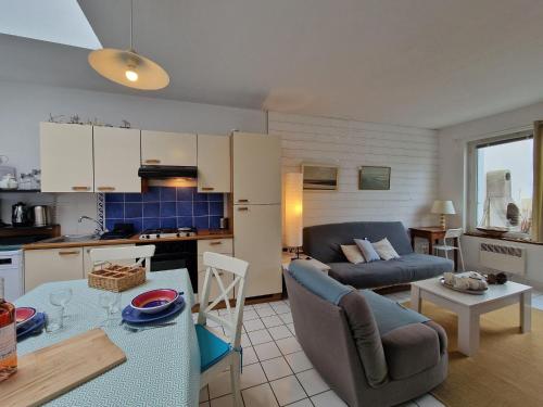Il dispose d'une cuisine et d'un salon avec un canapé et une table. dans l'établissement Apartment in Plougasnou near Sandy Beach, à Plougasnou