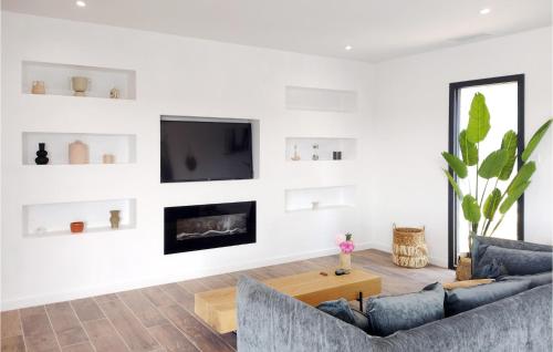 un salon avec un canapé et une télévision sur un mur dans l'établissement Awesome Home In Malves En Minervois, à Malves