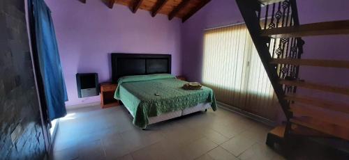 1 dormitorio con 1 cama con colcha verde en Munzsant en Catriel