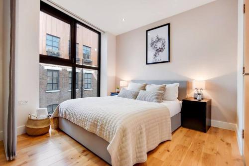 a bedroom with a large bed and a large window at BR5 - Charming Studio Flat in heart of Borough in London