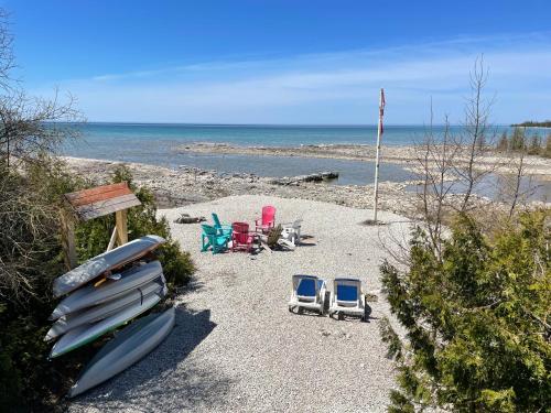a group of chairs and surfboards on a beach at Home of the Living Sunset in Miller Lake