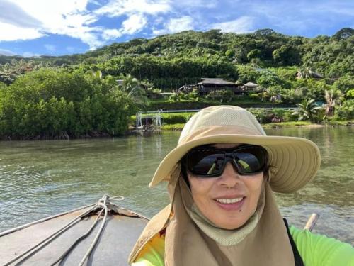 a woman in a hat on a boat on a river at Tehuarupe Surf Studio 2 in Haapiti