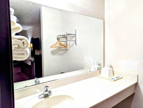 a bathroom with a sink and a large mirror at Luxury inn in Mustang