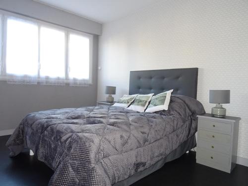 une chambre avec un lit avec deux oreillers dessus dans l'établissement Appartement T3 vue sur mer, proche plage - FR-1-92-878, à Les Sables-dʼOlonne