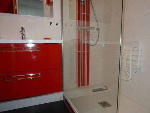 La salle de bains est pourvue d'une armoire rouge et d'une douche. dans l'établissement Appartement T3 vue sur mer, proche plage - FR-1-92-878, à Les Sables-dʼOlonne