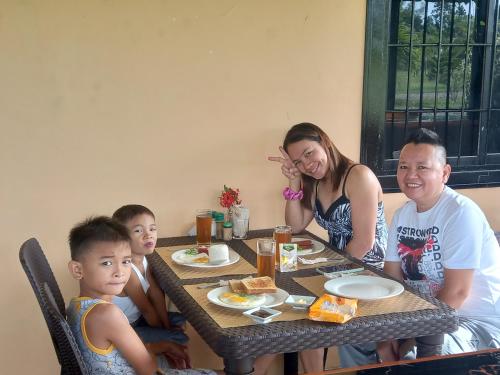 a group of people sitting at a table eating food at Green Acres Village in Moalboal