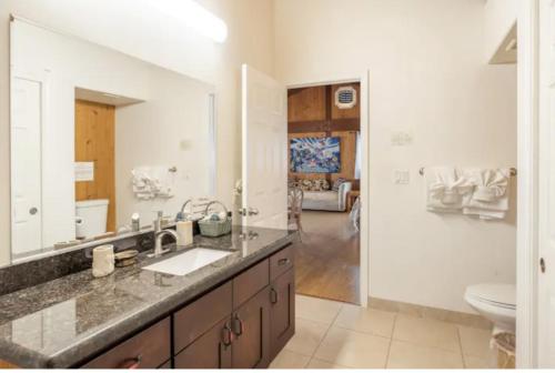 een badkamer met een wastafel, een toilet en een spiegel bij Serenity Hale in Papa Bay Estates