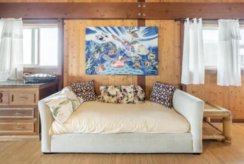 a white couch in a room with a painting at Serenity Hale in Papa Bay Estates