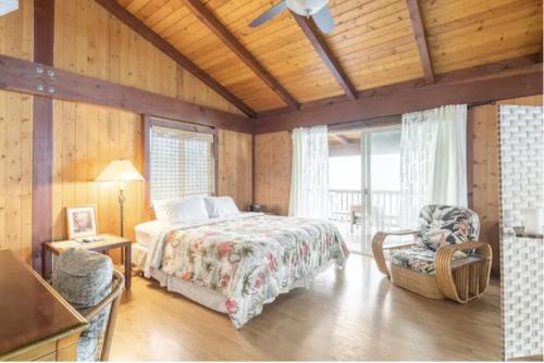 a bedroom with a bed and a chair in a room at Serenity Hale in Papa Bay Estates