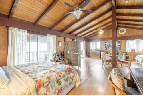 een slaapkamer met een bed en een plafondventilator bij Serenity Hale in Papa Bay Estates