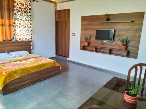 a bedroom with a bed and a flat screen tv at Samith Home Stay in Madikeri