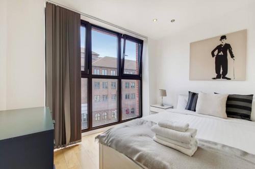 a bedroom with a bed with a large window at BR6 - Beautiful 1 bed flat in heart of borough in London