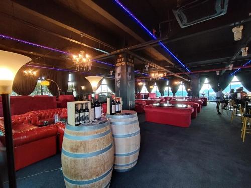 a bar with wine barrels in a room with red couches at reSTARY - Music, Sutera Avenue Infinity Pool - Imago Opposite - KK City- 2BR,8Pax 来沙旅 歌唱主题公寓 - 无边际日落海景泳池 - Imago商场对面 - KK市中心 - 2房8人 in Kota Kinabalu