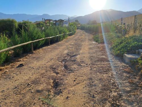 a dirt road with the sun in the distance at Hermosa Cabaña en Colliguay in Cerro Viejo