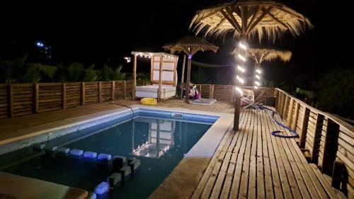a swimming pool with a deck at night at Hermosa Cabaña en Colliguay in Cerro Viejo
