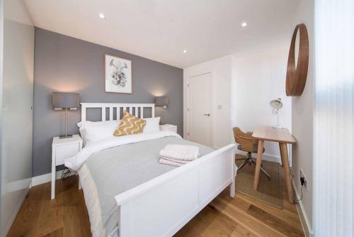a white bedroom with a white bed and a desk at 7 Borough Apartments - Spacious 2-Bed, 2-Bath in Prime Location in London