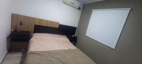 ein kleines Schlafzimmer mit einem Bett und einem Fenster in der Unterkunft Quinta Los Pinos Paraná in Paraná