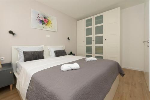 a bedroom with a large bed with two towels on it at Apartment Cute in Omiš