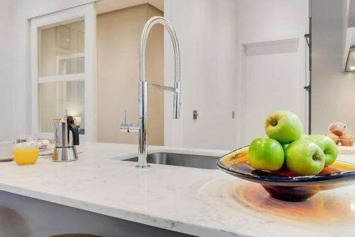 a bowl of apples on a plate on a kitchen counter at Number 8 Borough Apartments 2 Bed 2 Bath in London