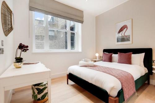 a bedroom with a bed and a desk and a window at 9 Borough Apartments - Spacious 2-Bed, 2-Bath Steps from London Bridge in London