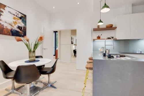 a kitchen with a table and chairs in a kitchen at 9 Borough Apartments - Spacious 2-Bed, 2-Bath Steps from London Bridge in London