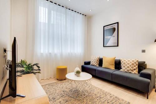 a living room with a couch and a tv at 9 Borough Apartments - Spacious 2-Bed, 2-Bath Steps from London Bridge in London