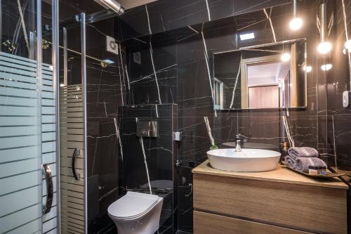 La salle de bains est pourvue d'un lavabo, de toilettes et d'un miroir. dans l'établissement Andys House, à Héraklion