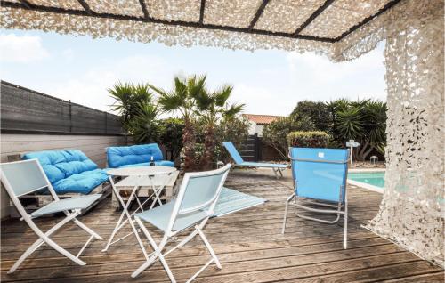 une terrasse avec des chaises bleues, une table et une piscine dans l'établissement Amazing Home In Saint-Marcel-Sur-Aude, à Saint-Marcel