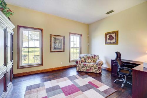 a living room with a chair and a desk and windows at Spacious Merritt Island Home Private Pool and Dock! in Merritt Island