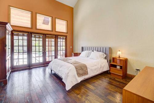 a bedroom with a large bed and windows at Spacious Merritt Island Home Private Pool and Dock! in Merritt Island
