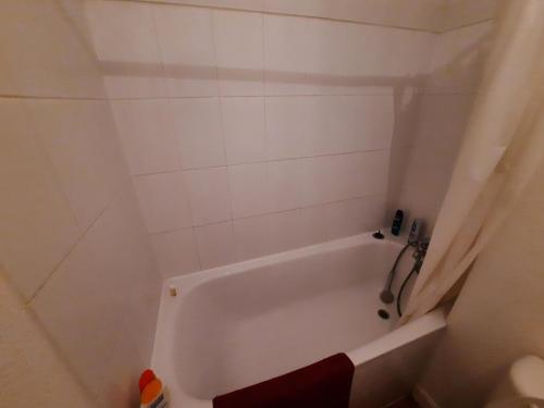 - białą wannę w wyłożonej białymi kafelkami łazience w obiekcie Charmant T2 au cœur de Bayonne, proche commodités - FR-1-239-891 w Bajonnie