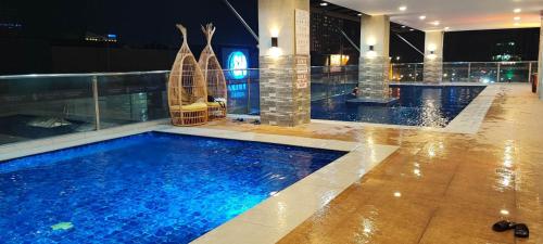 a large swimming pool in a hotel at night at SUNVIDA TOWER, across SM City Cebu in Mandaue City