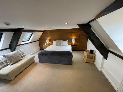 ein Schlafzimmer mit einem Bett und einem Sofa in einem Zimmer in der Unterkunft The Castle Hotel in Llandovery