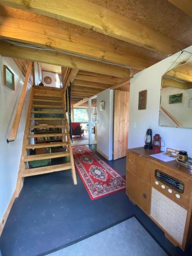 a small kitchen with a staircase in a tiny house at Alpacas Off Grid - Eco Cabin in Takaka