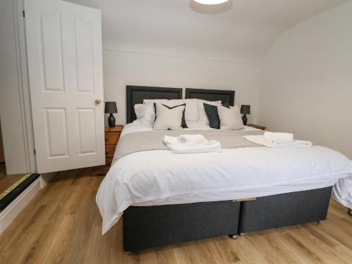 a bedroom with a large bed with two towels on it at 4 Green Farm Cottage in Chester