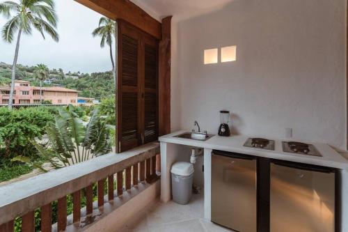 Il comprend une cuisine avec un comptoir et un balcon avec vue. dans l'établissement Loft - 1 bedroom in El Careyes Club, à Careyes