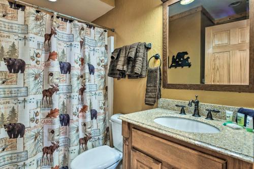 a bathroom with a shower curtain with a toilet and a sink at Bryson City Cabin Rental with Mountain View, Hot Tub in Bryson City