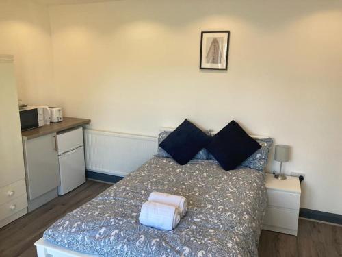 a bedroom with a bed with blue pillows at Newly refurbished studio, great location 8 studios in Nottingham
