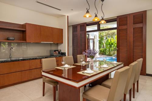 cocina y comedor con mesa y sillas en Resort Villa Da Nang Luxurious, en Da Nang