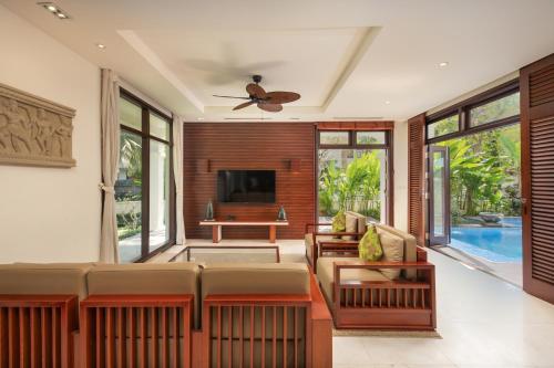 sala de estar con sofá y TV en Resort Villa Da Nang Luxurious, en Da Nang